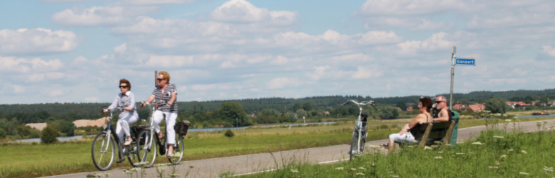 two people biking in between fields