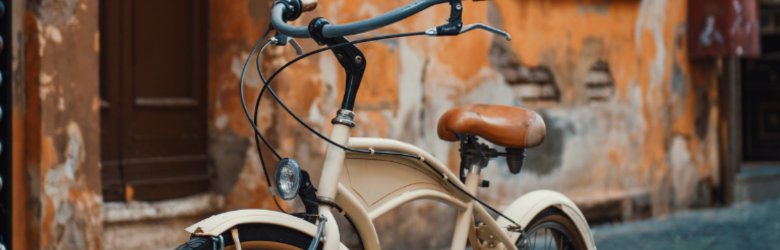 old bike standing in front of an orange wall